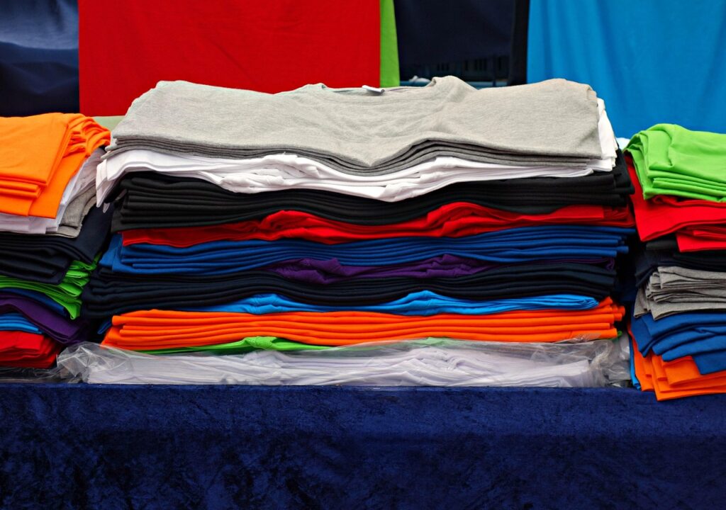 t-shirt, tee, clothing, garment, shirt, fashion, unisex, woman, man, top, casual, pile, pile of t-shirts, market, stall, market stall, t-shirt, t-shirt, t-shirt, t-shirt, t-shirt, shirt, shirt, shirt