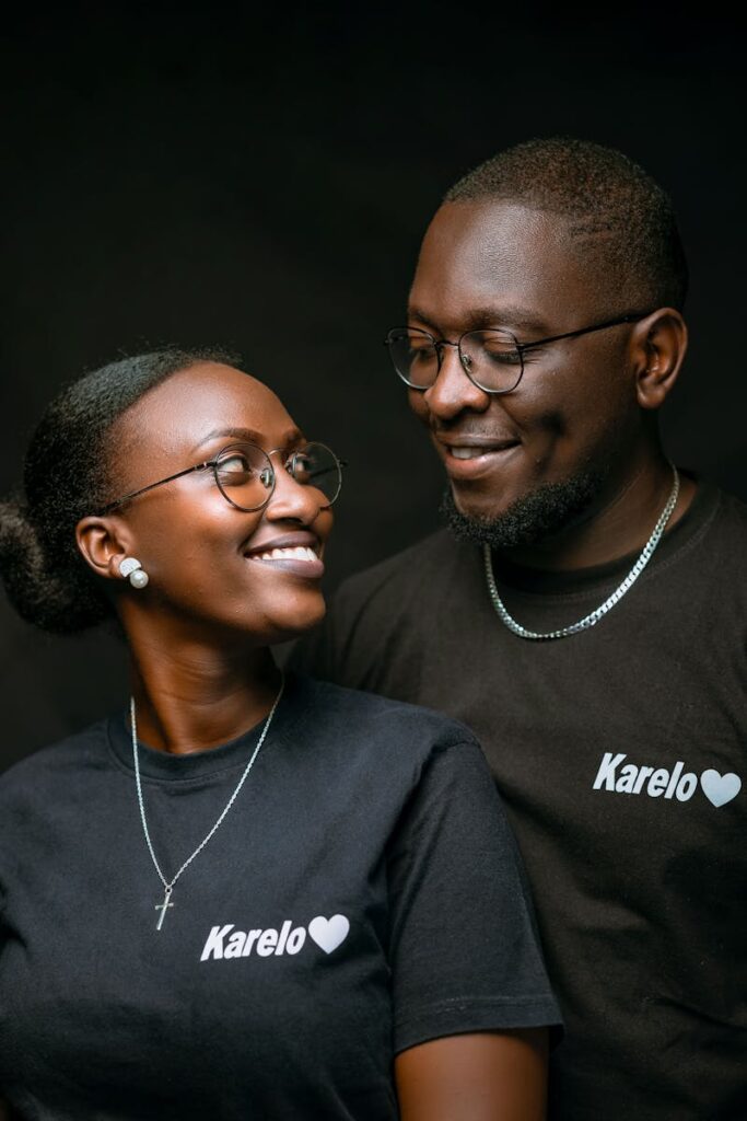 Happy couple wearing matching Karelo shirts, smiling and looking at each other.