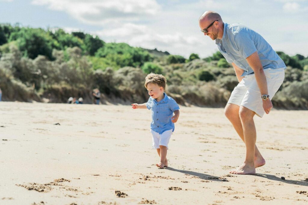 Father and son bonding moment while playing on a sunny beach day.