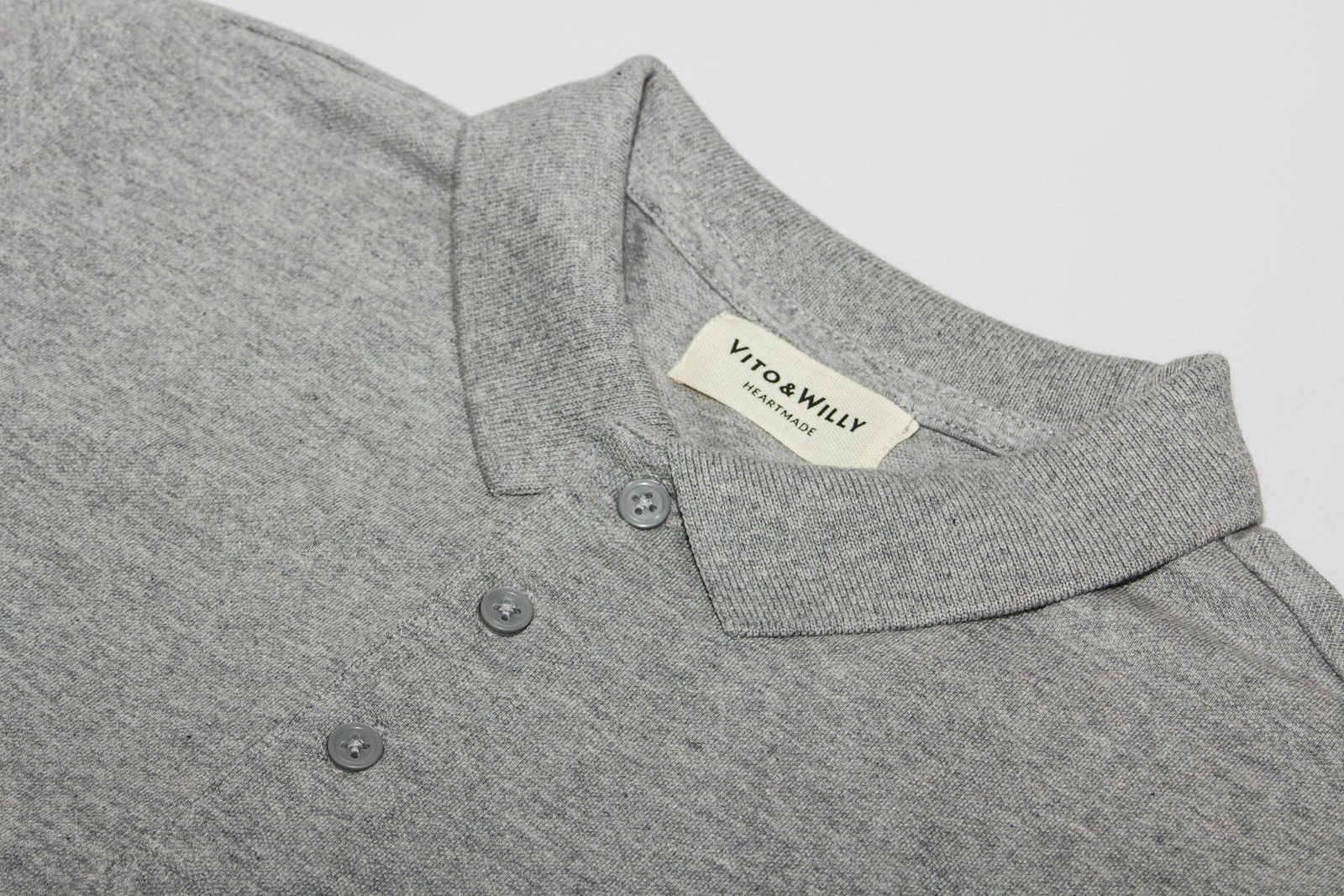 gray polo shirt on white table custom clothing tags