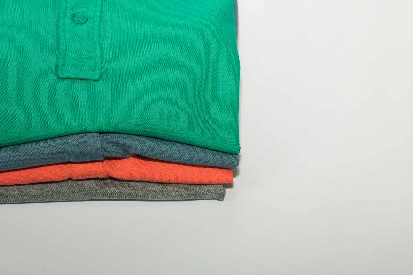 green polo shirt on white table Custom Polo Shirts