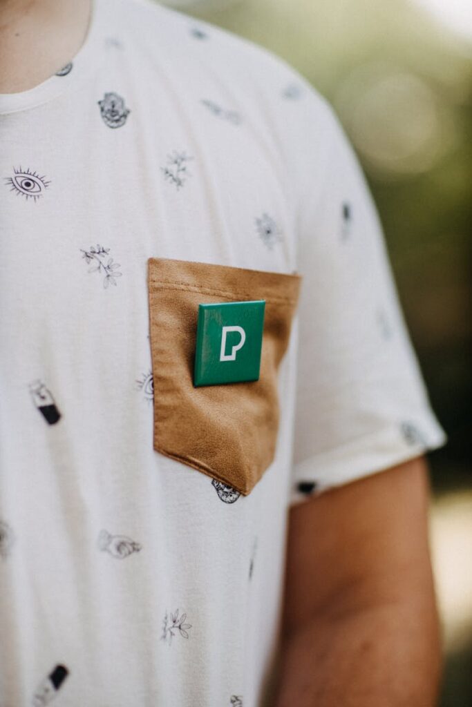 Close-up of man wearing a trendy graphic t-shirt with a distinctive pocket and design emblem.