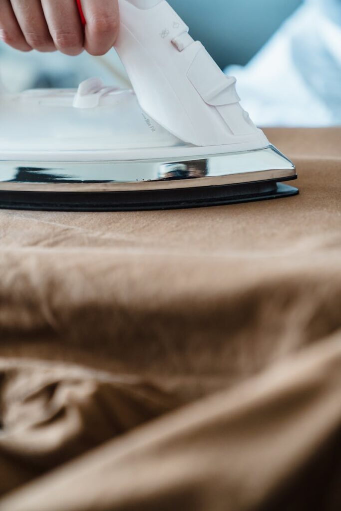 Detailed shot of an iron smoothing cloth, focusing on the ironing process.