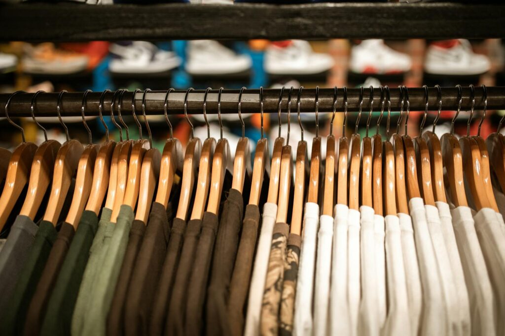 Row of colorful shirts on hangers in a clothing store, offering trendy fashion choices.