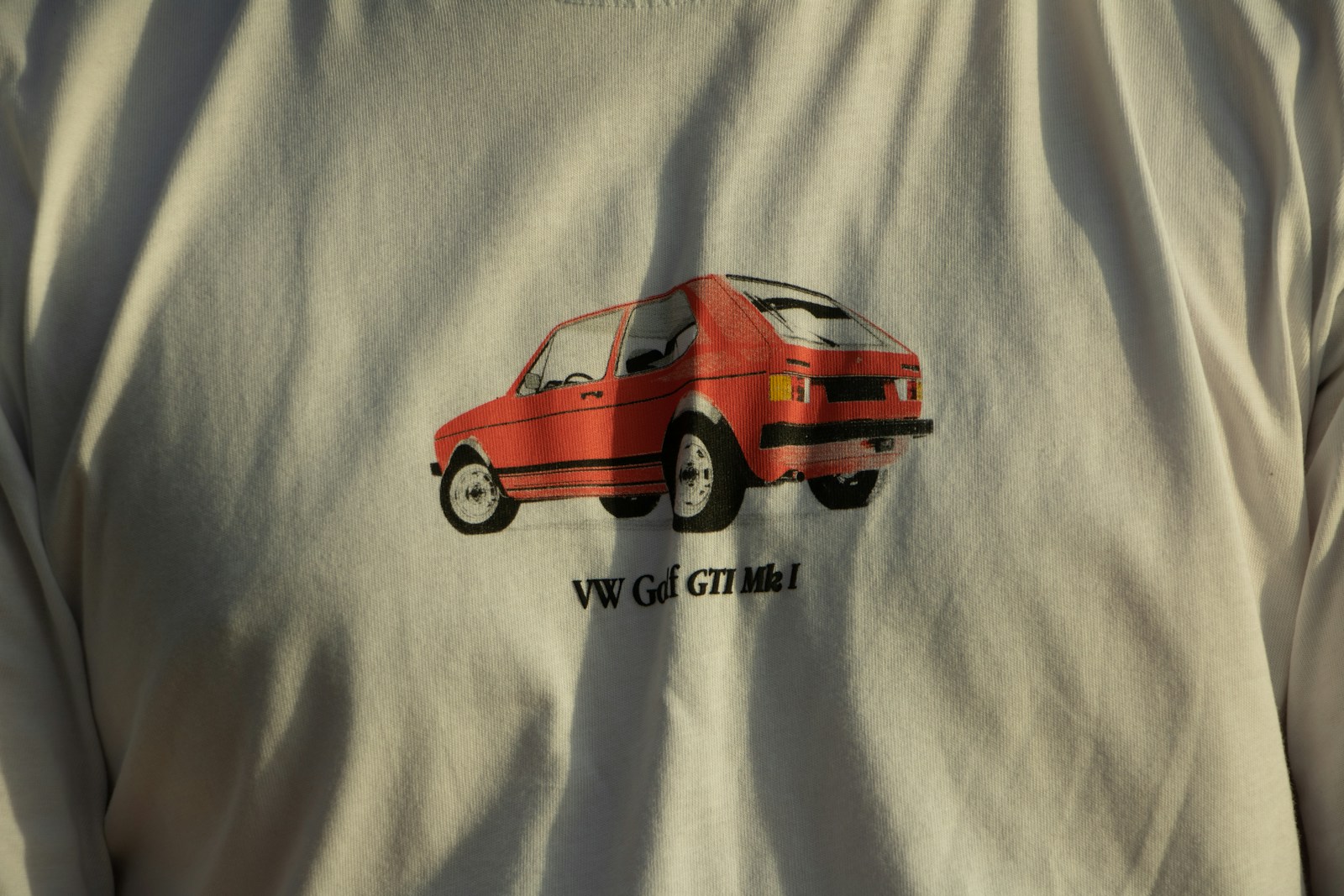 a man wearing a white shirt with a red car on it Shirt Design Maker