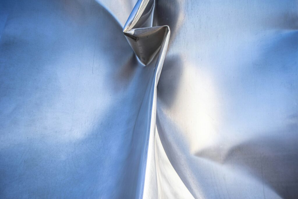 a close up of a metal sheet with a blue background