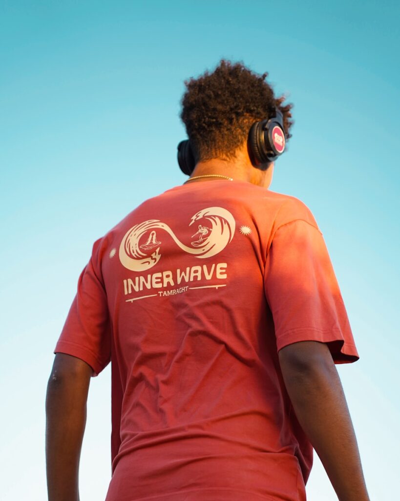 Man enjoys music, wearing headphones and a shirt.