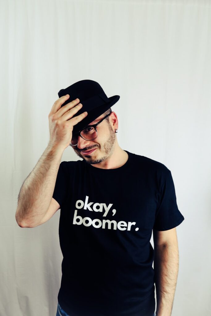 man in black crew neck t-shirt wearing black fedora hat