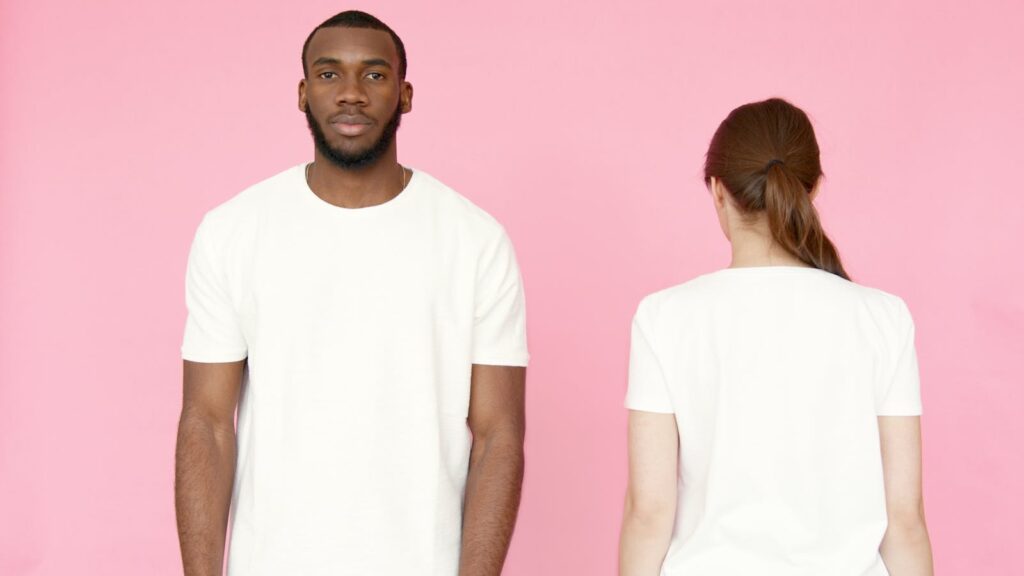 Two models showcasing white t-shirts on a pink background, front and back views.