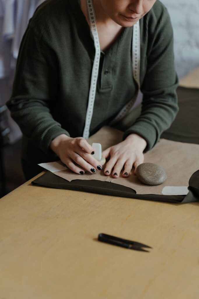 A fashion designer marking patterns on fabric in an atelier, showcasing bespoke tailoring.