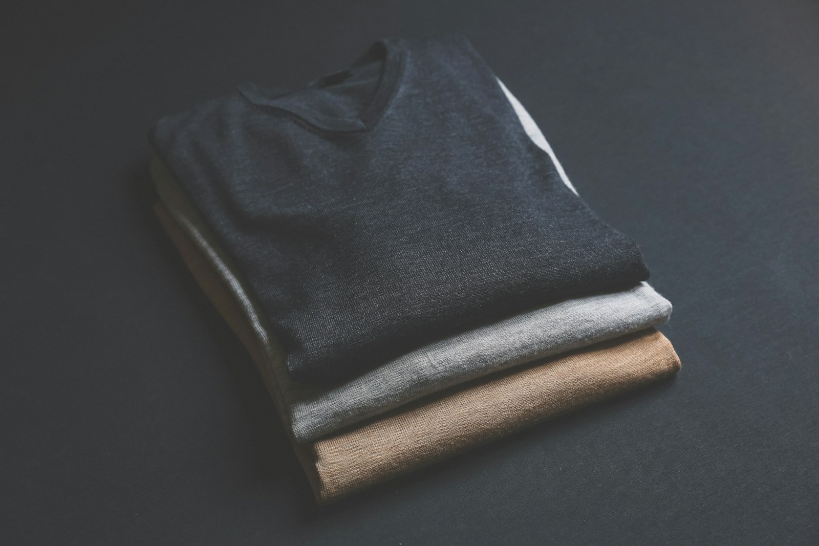 Photo by Mnz three black,grey,and brown V-neck shirt on black surface (DTF Transfers) | Everything You Need to Start Printing Today