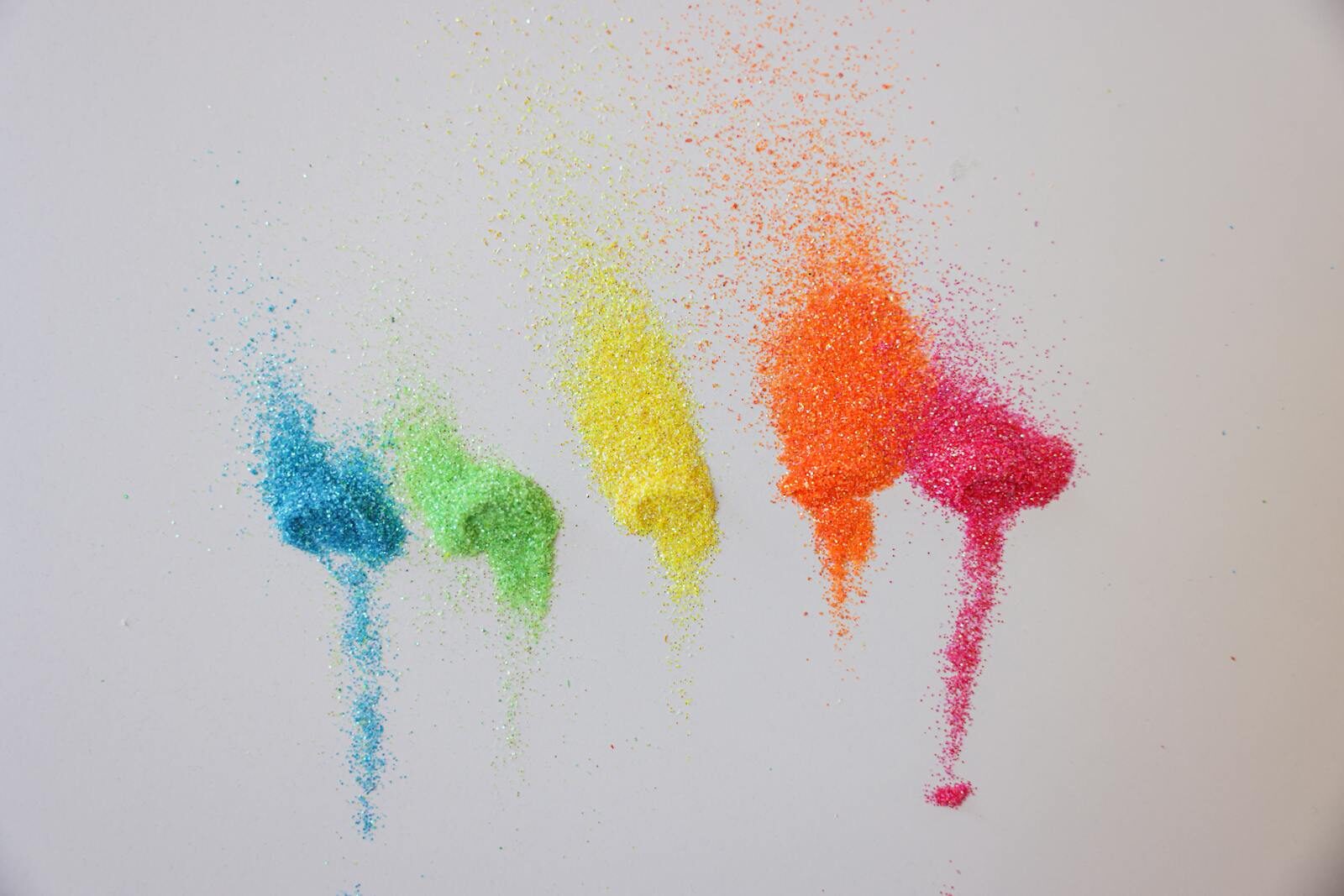 Photo by Cup of Couple Bright colored powder arranged on a white background, showcasing vivid rainbow hues.