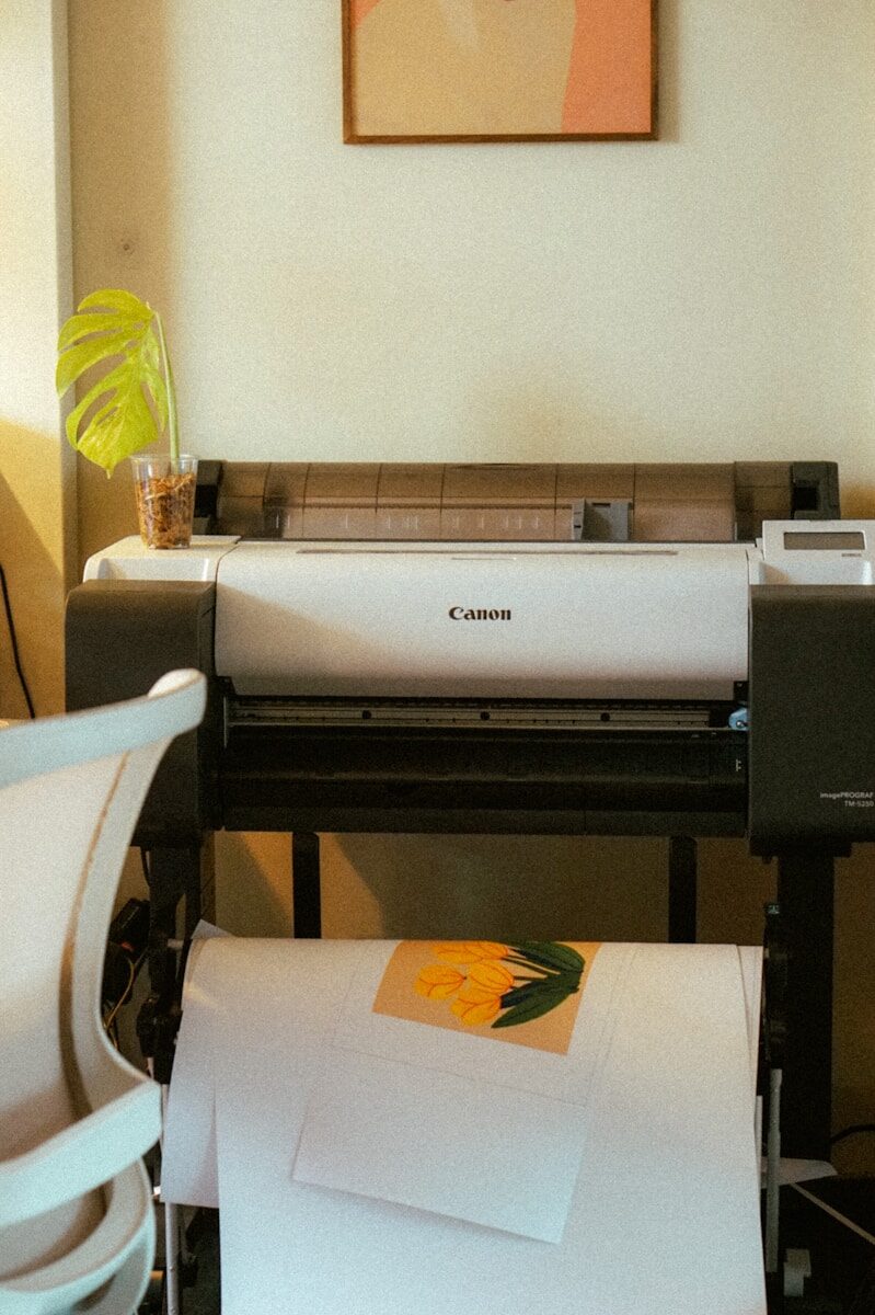 A large format printer with paper and artwork.