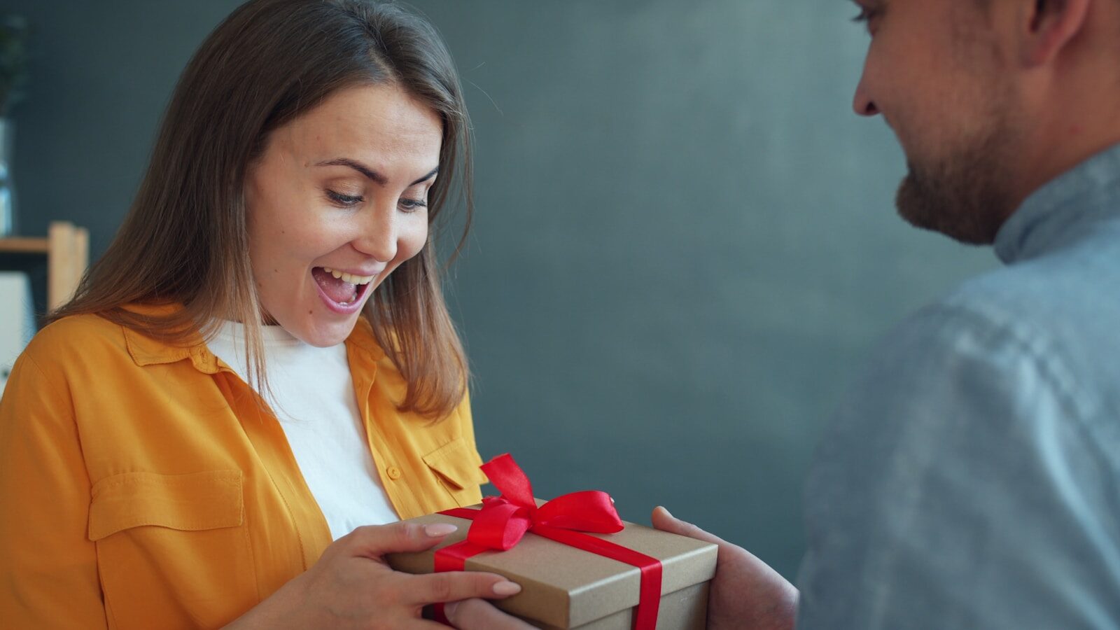 Photo by Vitaly Gariev Woman happily receiving a gift from man