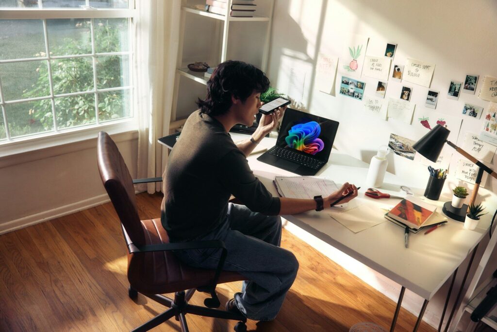 Person working at a desk with a laptop and books.