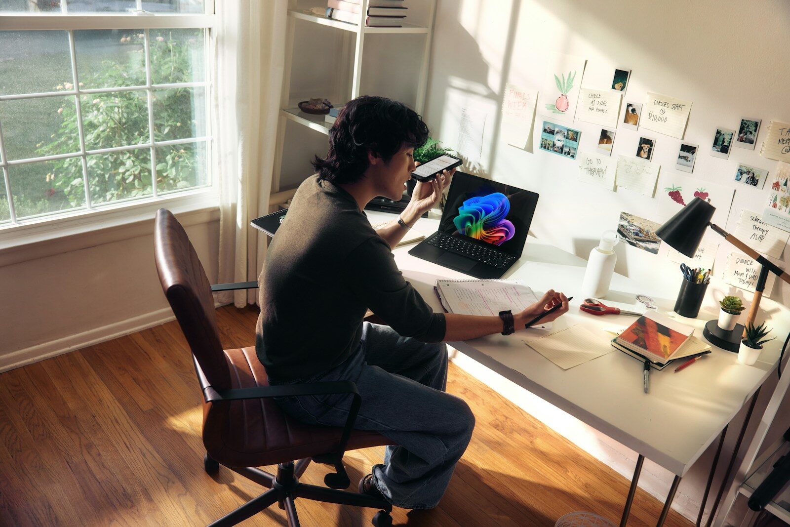 Photo by Microsoft Copilot Person working at a desk with a laptop and books.