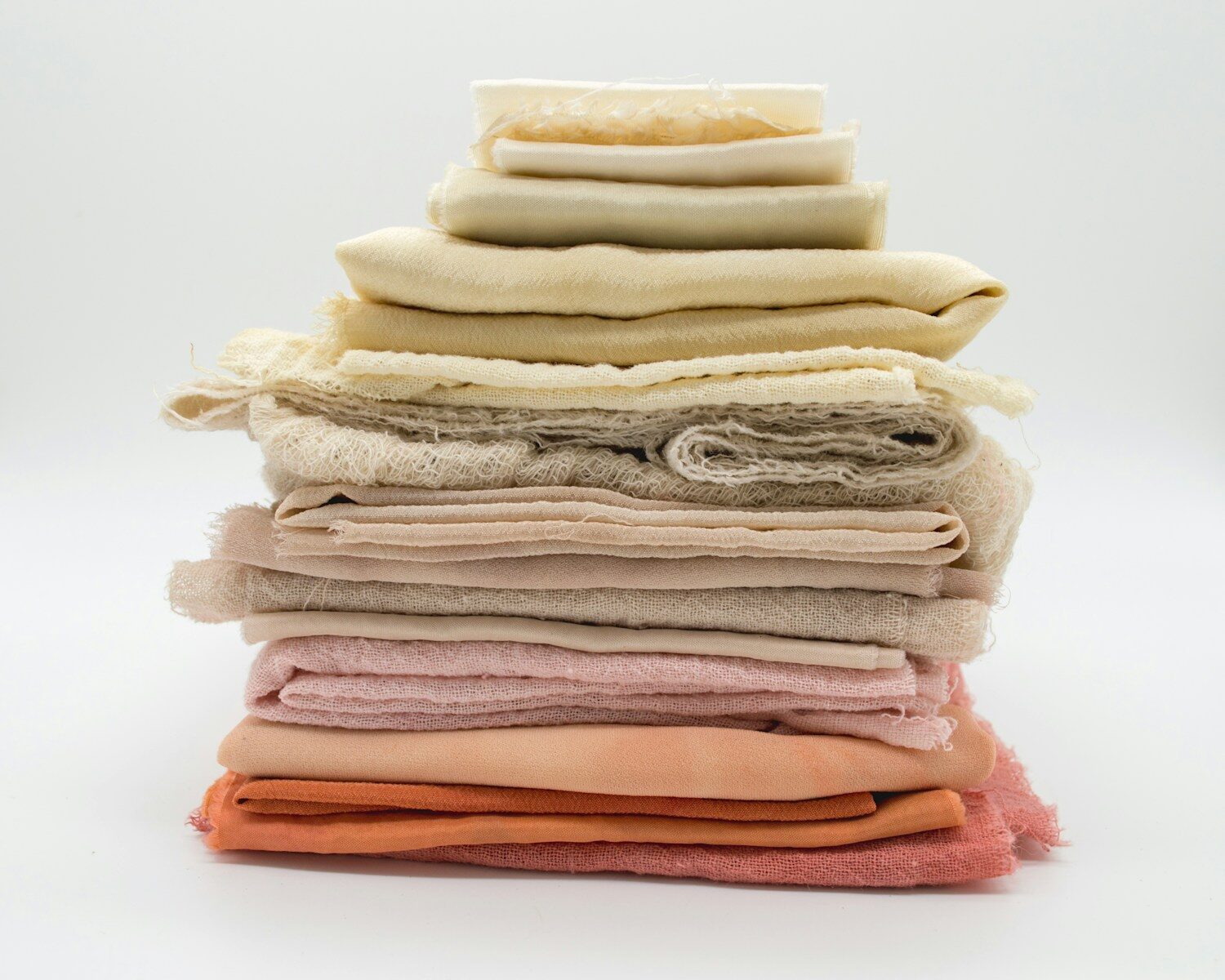 pile of cloth on white surface Rayon vs Cotton: Which Fabric Works Best for DTF Printing?