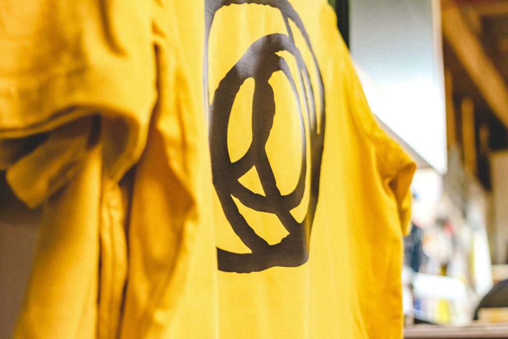 Yellow t-shirt with a black circular symbol.