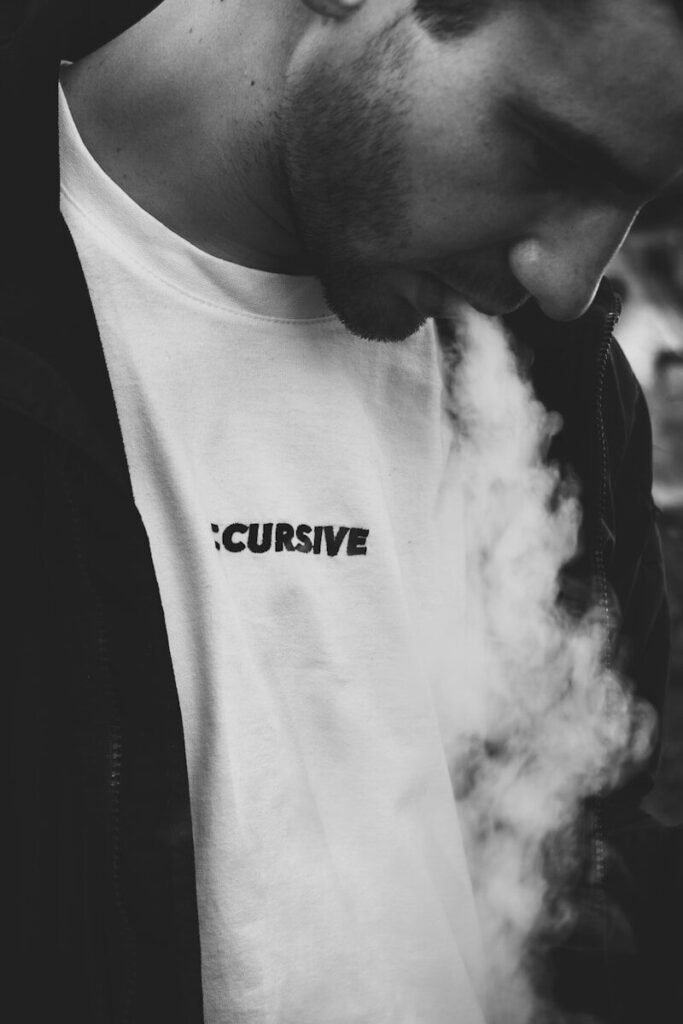 grayscale photography of man smoking