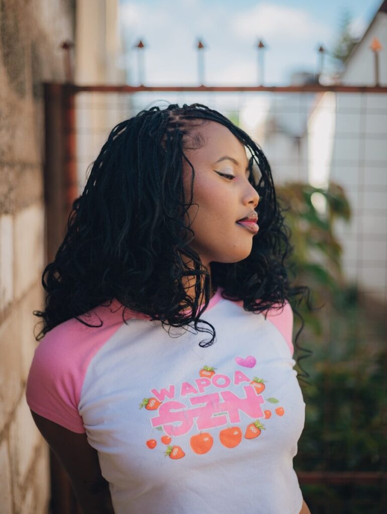 Woman with braided hair wearing a pink and white shirt
