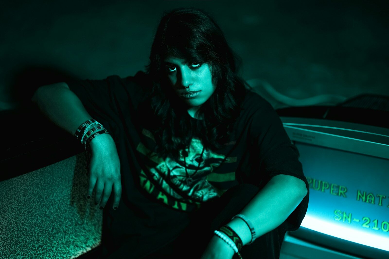 Young person with dark hair and bracelets sits. 7 Benefits of Direct to Film Transfers for Small Businesses