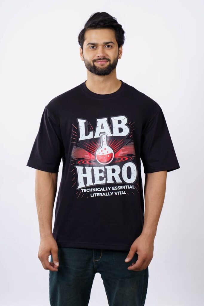 Front view of a man wearing a black 'Lab Hero' T-shirt with a science-themed design.