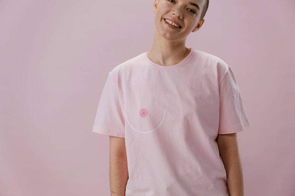Smiling person in pink shirt symbolizing breast cancer awareness with abstract design. DTF Transfers Best Practices: How to Get Perfect Results Every Time