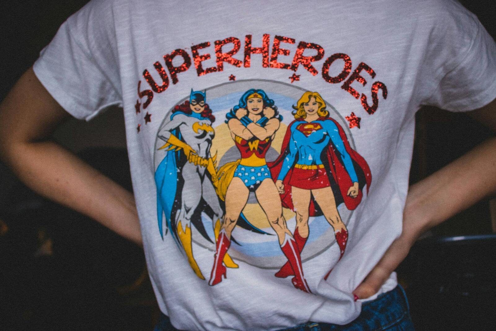 A vibrant superhero themed t-shirt featuring female comic characters in a bold design. DTF Transfers vs Vinyl: Which Printing Method Wins?
