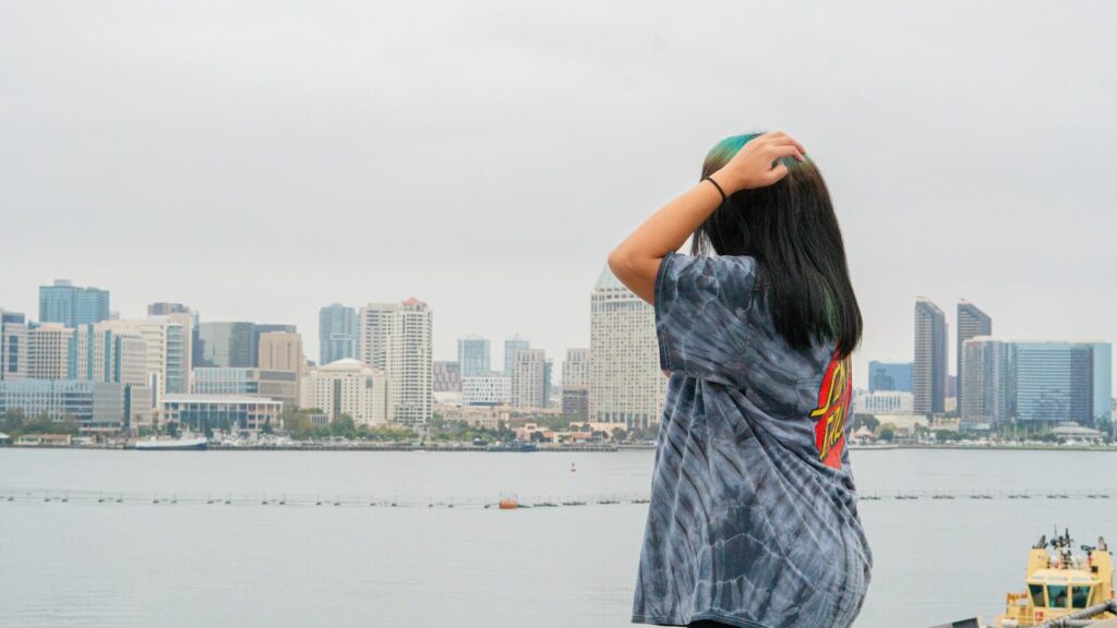 Woman views a city skyline on a cloudy day.