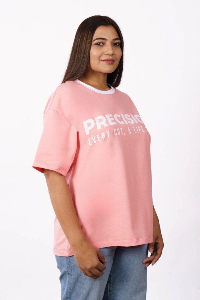 A woman wearing a pink t-shirt and jeans.