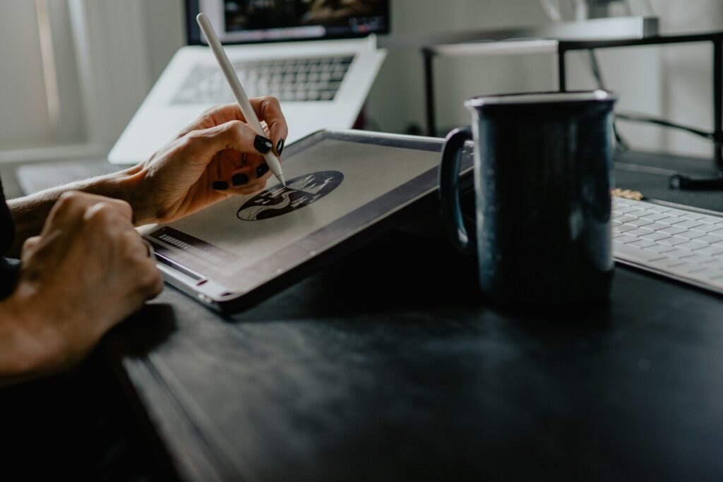A person drawing on a tablet with a stylus at a desk