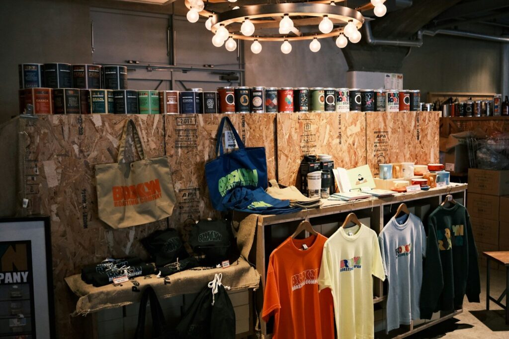 Shop interior featuring apparel, accessories, and cans on wooden displays.
