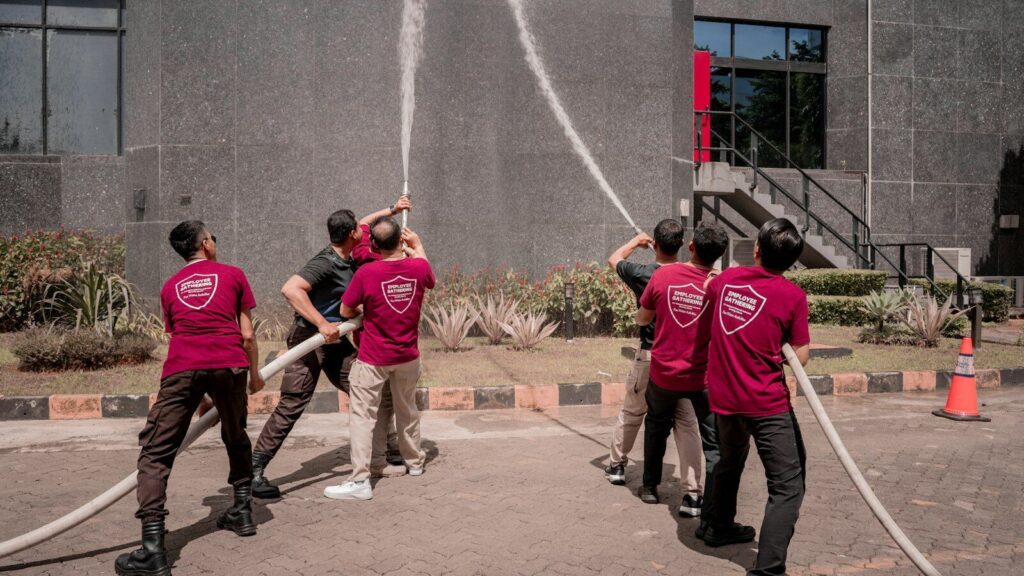 Group practicing with fire hose outside building